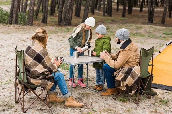 Mädchen gießt heißen Tee für Familie auf Reise — Stockfoto