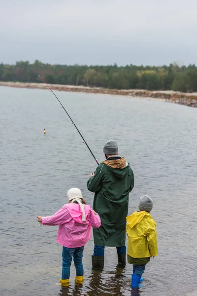 Отец и дети рыбачат вместе — стоковое фото