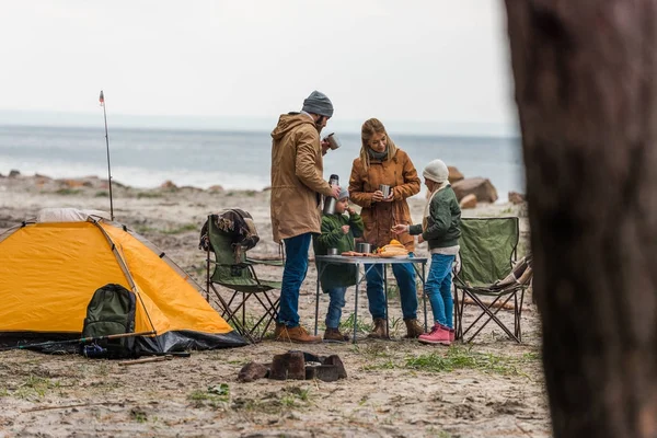 Familia teniendo campamento en la orilla del mar - foto de stock