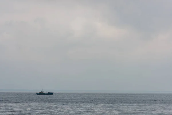Barco solitario flotando en el mar - foto de stock