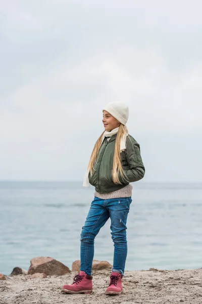 Chica de pie solo en la orilla del mar - foto de stock