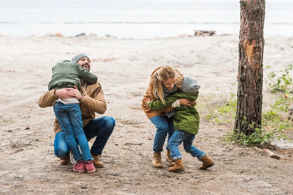 Familia divirtiéndose en la orilla del mar - foto de stock