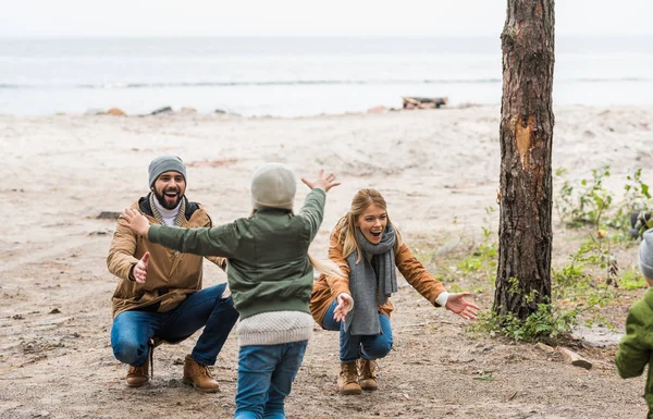 Enfants courant vers les parents au bord de la mer — Photo de stock