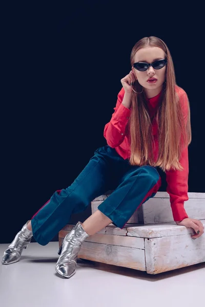 Mujer con camisa roja sentada en las escaleras - foto de stock