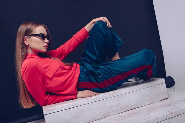 Menina em camisa vermelha deitada nas escadas — Fotografia de Stock