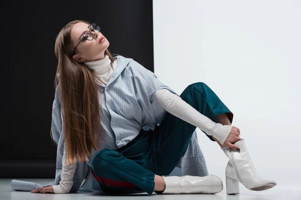 Frau in stylischem Outfit sitzt auf dem Boden — Stockfoto