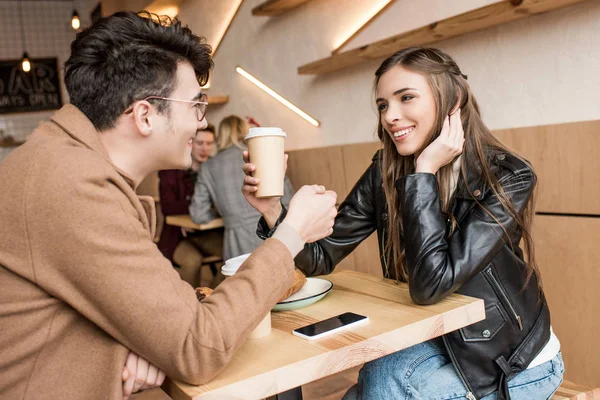 Parejas sentadas con café en la cafetería - foto de stock