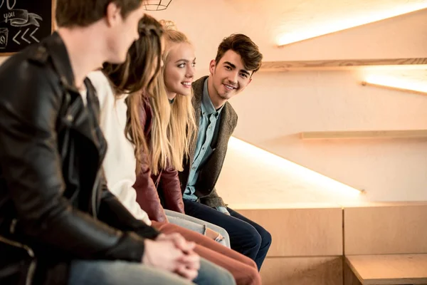 Friends sitting on bar counter — Stock Photo