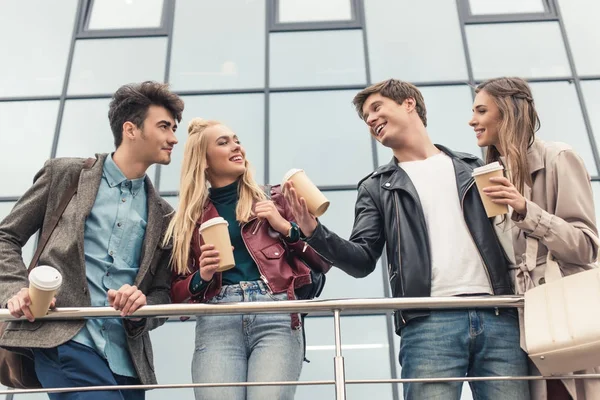 Quatre amis avec tasses à café jetables — Photo de stock