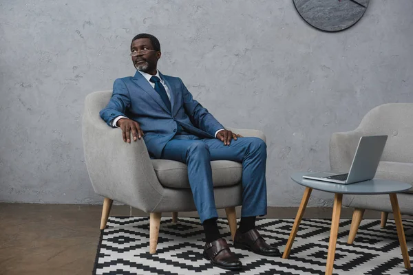 Businessman sitting in armchair — Stock Photo