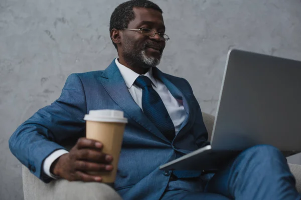 Homem de negócios sentado com laptop e café — Fotografia de Stock