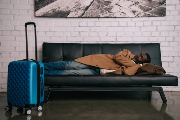 Человек спит на черном диване — стоковое фото