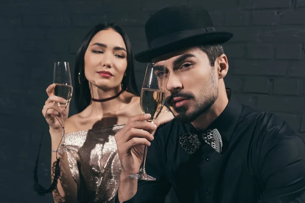 Багатоетнічна пара в келихах шампанського — стокове фото
