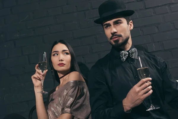 Élégant couple multiculturel avec des verres de champagne — Photo de stock