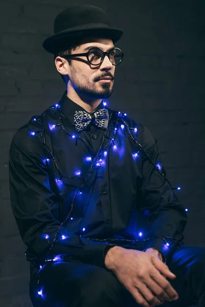 Fashionable man with christmas lights — Stock Photo