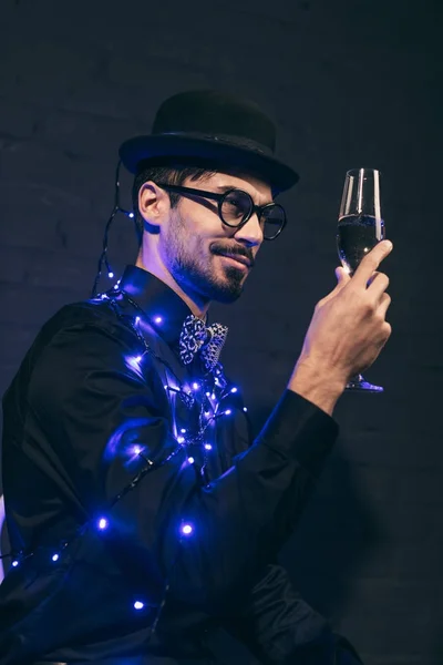 Людина з шампанським і різдвяними вогнями — стокове фото