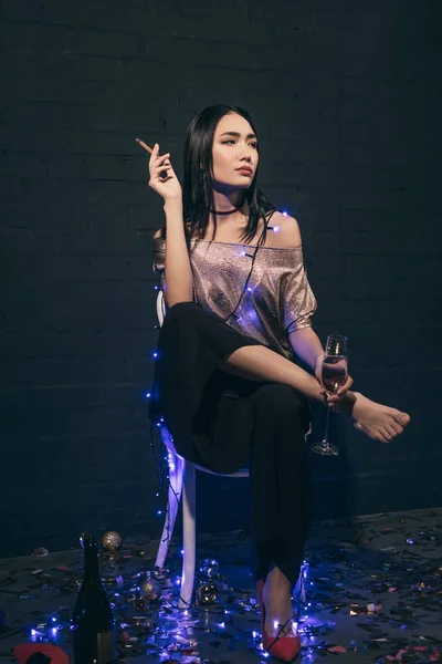 Mujer asiática con cigarrillo y champán - foto de stock