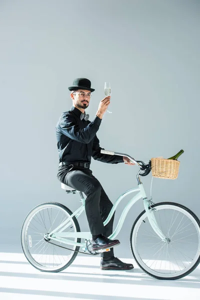 Homme sur vélo rétro avec coupe de champagne — Photo de stock