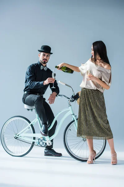 Asian woman pouring champagne into glass — Stock Photo