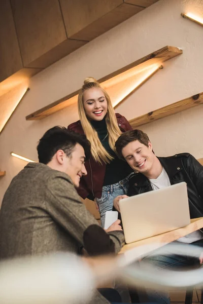 Friends laughing and looking at laptop — Stock Photo
