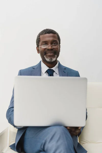 Uomo sorridente che lavora con il computer portatile — Foto stock