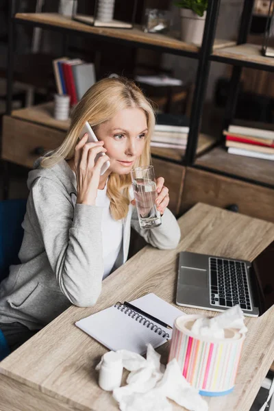 Frau trinkt Wasser und spricht auf Smartphone — Stockfoto