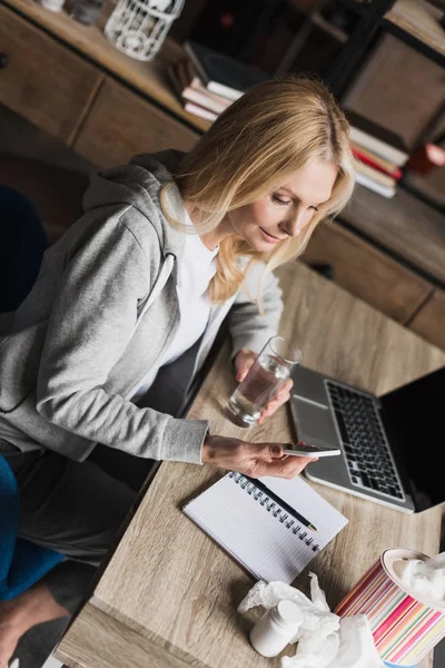 Kranke Frau nutzt Smartphone — Stockfoto