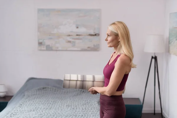 Frau mit Yogamatte zu Hause — Stockfoto