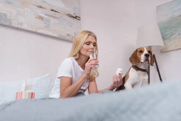Kranke Frau mit Hund zu Hause — Stockfoto