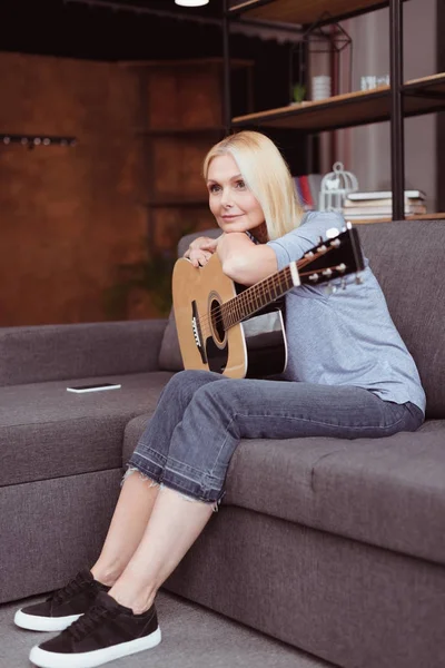 Frau mittleren Alters mit Gitarre zu Hause — Stockfoto