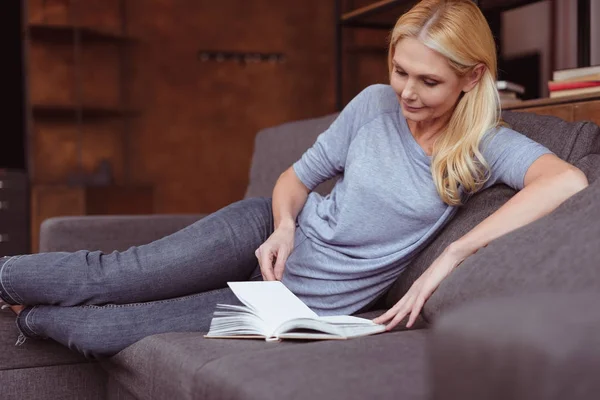 Mujer leyendo libro en casa - foto de stock