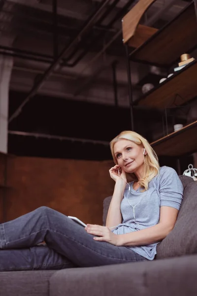 Woman in earphones using smartphone — Stock Photo