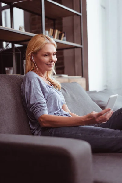 Woman in earphones using smartphone — Stock Photo