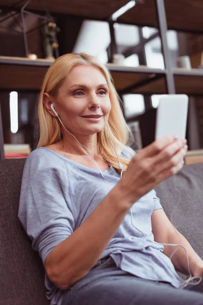 Mujer en auriculares usando smartphone - foto de stock