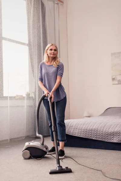 Femme avec aspirateur à la maison — Photo de stock