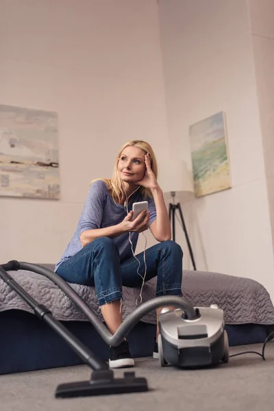 Aspirateur et femme avec smartphone — Photo de stock