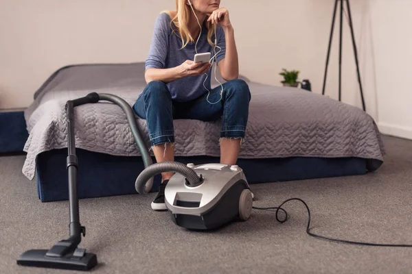 Aspirateur et femme avec smartphone — Photo de stock