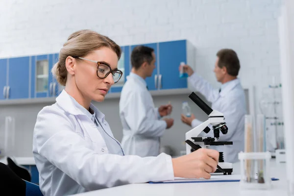 Technicien de laboratoire prenant des notes — Photo de stock