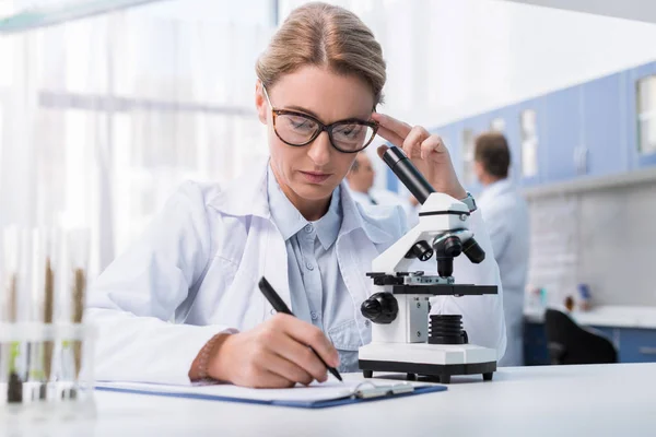 Técnico de laboratorio tomando notas - foto de stock