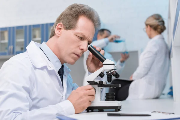 Scientist working with microscope — Stock Photo