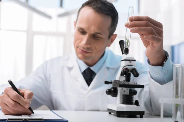 Lab technician taking notes — Stock Photo