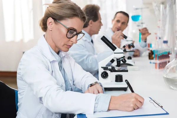 Lab technician taking notes — Stock Photo