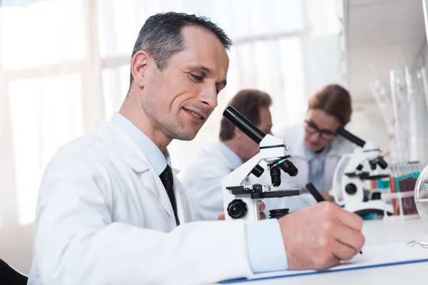 Lab technician taking notes — Stock Photo