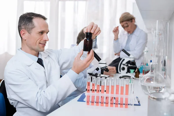 Cientista segurando frasco com produto químico — Fotografia de Stock