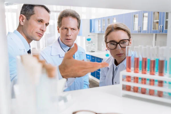 Scientists with test tubes — Stock Photo