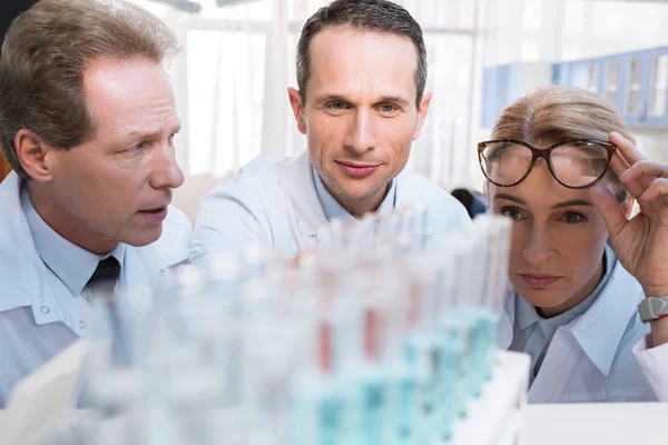 Chemists with test tubes — Stock Photo