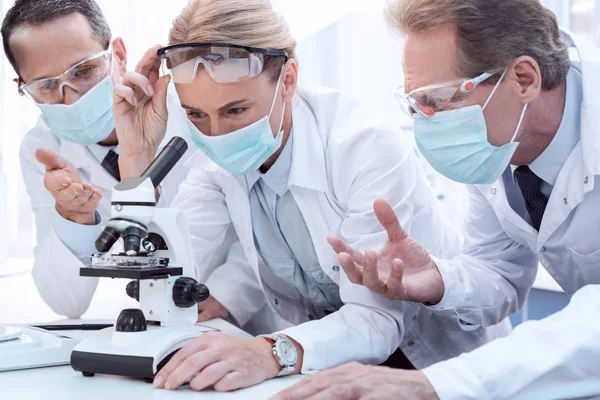 Doctors using microscope — Stock Photo