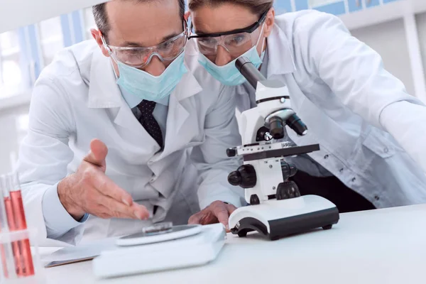 Médecins faisant une analyse au microscope — Photo de stock