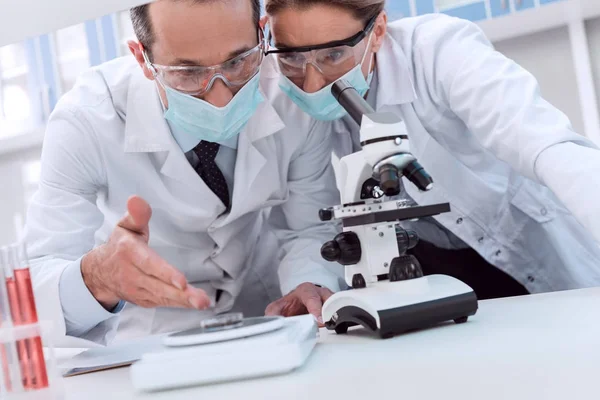 Médicos haciendo análisis de microscopio - foto de stock