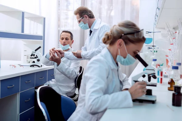 Químico haciendo análisis de microscopio - foto de stock